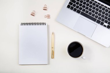 Dizüstü bilgisayarlı hafif ofis masası, beyaz defter modeli ve kahve fincanı.. 