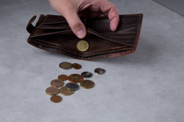 Cüzdanından bozuk para döken bir adamın eli.