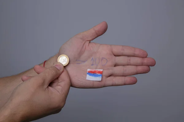 Hombre de la mano tiene moneda de euro y en el otro curso de la palma de 100 rublos está escrito — Foto de Stock