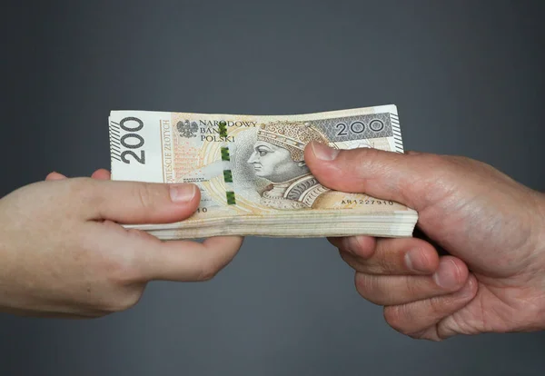 Mano masculina dando un paquete de billetes grandes a manos femeninas. — Foto de Stock