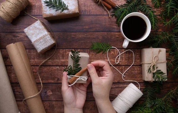 Las manos hacen regalo de Navidad en la mesa de madera — Foto de Stock
