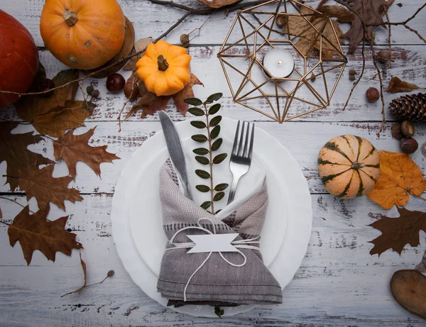 stock image composition on the table with yellow leaves, cutlery and pumpkins