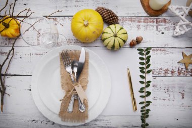 Çatal bıçak, balkabağı ve sarı yapraklar için bir tabak ile sonbahar kompozisyonu.