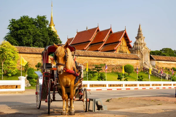 Horse carriage stand in front of Wat Phra That Lampang Luang, an ancient magnificent Lanna architecture in Lampang province, Thailand