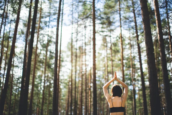 Mulher praticando ioga na floresta com namaste sobre a cabeça. estilo de vida fitness ao ar livre natureza fundo. Dia ensolarado em pinhal. espaço de cópia — Fotografia de Stock