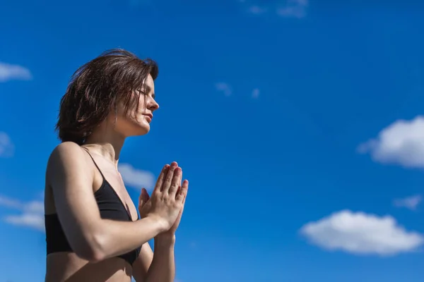 Mulher praticando ioga com namaste nas costas. estilo de vida fitness no fundo céu ao ar livre. Dia ensolarado em pinhal. espaço de cópia — Fotografia de Stock