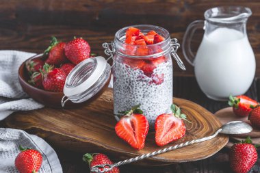 Çilek soslu chia pudingi, rusik arka planda taze dut ve süt