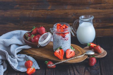 Çilek soslu chia pudingi, rusik arka planda taze dut ve süt
