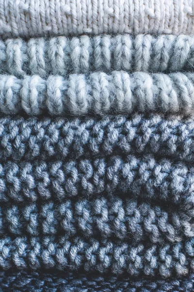 Pile de pulls en laine tricotés de couleurs noir et blanc. Vêtements avec différents motifs de tricot pliés en pile. Chaud confortable hiver automne tricot concept. gros plan — Photo