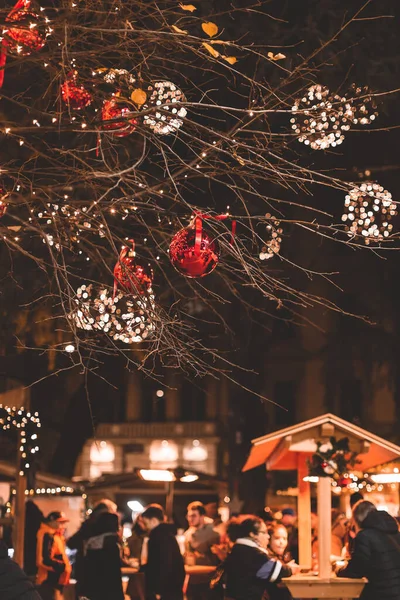 이탈리아의 디스코 쿠스 크리스마스 시장, 메라노의 밤 시장. 붉은 공과 빛으로 장식 된 나무. — 스톡 사진