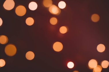 Odaklanamayan soyut Bokeh ışıkları arkaplanı. turuncu, kırmızı, siyah renkler. Noel ve yeni yıl konsepti