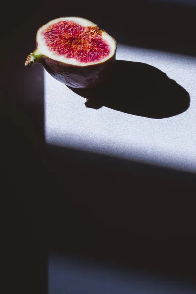 Figos frescos cortados com sombras sobre fundo escuro e branco. contraste sombra fruitf lat lay, vista superior, textura de frutas tropicais. Espaço de cópia — Fotografia de Stock