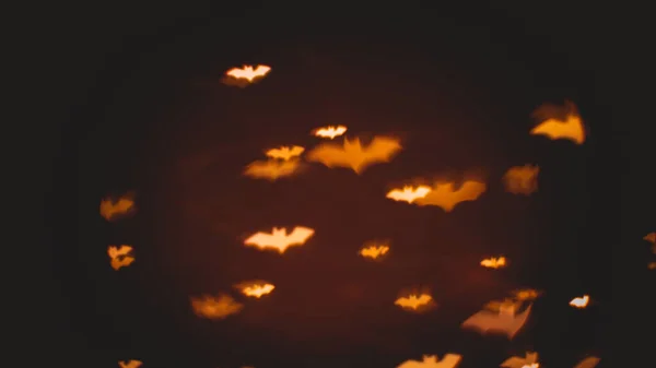 Defocused bokeh gold lights in shape of bats for halloween background - holidays, decoration and party concept — Stock Photo, Image