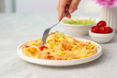 Gri masadaki beyaz kasede karidesli İtalyan makarnası. Ev yapımı güzel ulusal mutfağı kapatın.