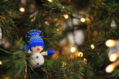 Noel ağacı süslemelerine yakın çekim. Beyaz, gümüş oyuncaklar ve altın ışıklarla süslenmiş firavun ağacı.