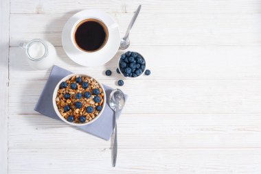 Tahıl gevreği ve yaban mersinli kahvaltı, kahve, portakal suyu ile süt ve beyaz ahşap masa üzerinde pişmiş tost fotokopi alanı ile birlikte yatıyordu. Sabahları yulaf ezmeli sağlıklı yiyecekler.