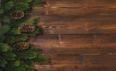 Köknar ağacı dalları ve ahşap arka planda koni süslemeleri olan yeni yıl ve Noel modeli