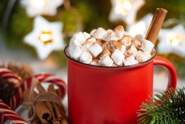 Kırmızı bardakta Macro noel içkisi, marşmelovlu tarçınlı ve anis yıldızlı. Yeni yıl kış bayramı kutlaması masası. Şenlikli dekorasyonlar