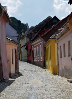 Taş, Avrupa 'nın Transilvanya bölgesindeki Sighisoara kalesinde renkli evleri olan eski sokakları asfaltladı.