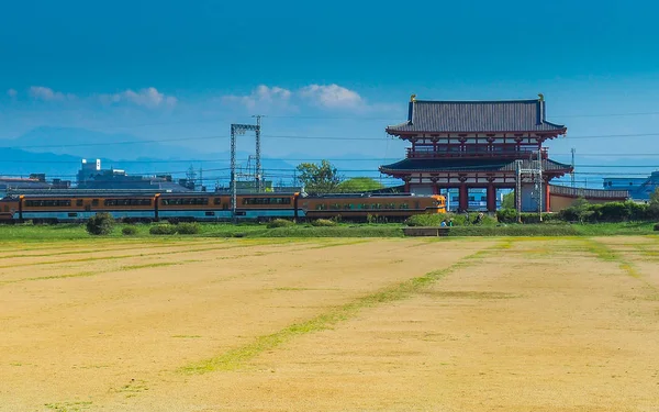 2017年4月23日 火车和自行车通过 Heijokyu 宫殿废墟的朱雀门 — 图库照片