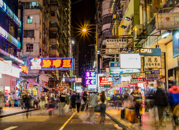 HONG KONG, KOWLOON - NOVEMBER 10, 2014: Busy and bright streets of Mongkok at night. A busy shopping and night market area lots of advertising and neon signs.