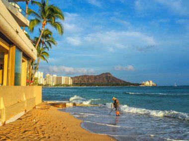 ABD, Hawaii - 29 Ağustos 2018: bir metal detektörü Waikiki beach günbatımında kullanan bir adam