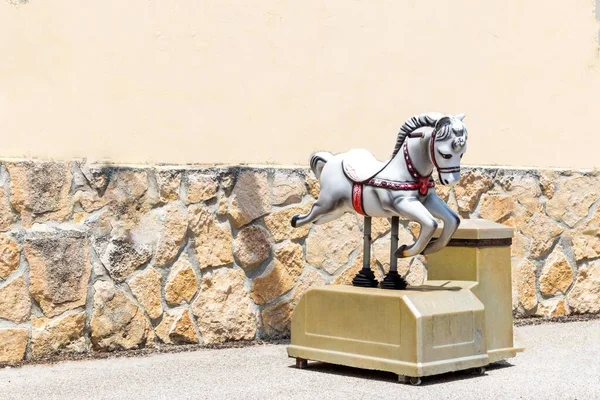 antique mechanical rocking horse for children and stone wall background