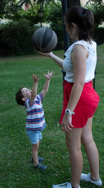 小さな男の子が年上の女の子にバスケットボールの選択的焦点を — ストック写真