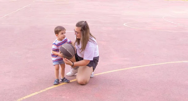 Jovem Menina Joelhos Ensinando Menino Para Jogar Basquete Foco Seletivo — Fotografia de Stock