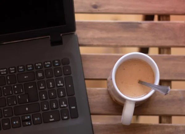 一个简单的桌子上的笔记本电脑和夏日一杯轻松的咖啡的细节 — 图库照片