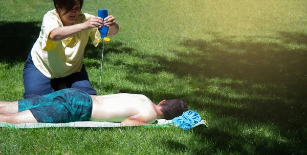 Jonge Man Slapen Het Gras Zonnebaden Een Moeder Spuiten Hem — Stockfoto