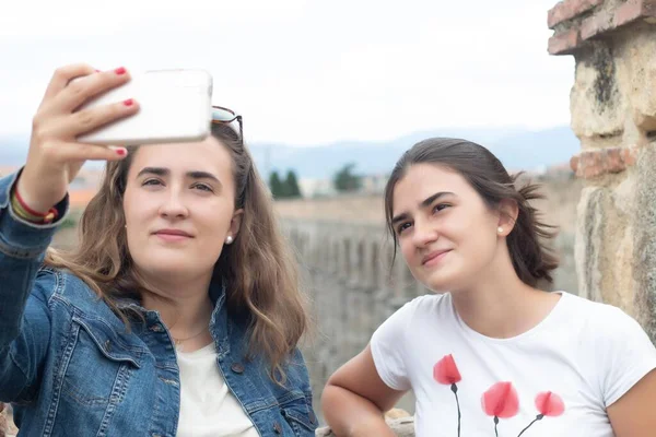 İspanya 'daki Segovia' nın su kemerlerinin anıtıyla bir yaz gününde selfie çeken iki genç.