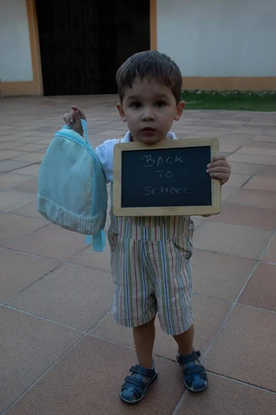 Bambino Mostrando Suo Zaino Una Lavagna Con Lettere Nuovo Scuola — Foto Stock