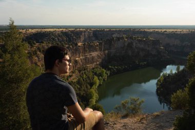 Güneşli bir günde İspanya 'nın Segovia kentinde bulunan Doğal Park Hoces del River Duratn manzarasını izleyen iki genç insan