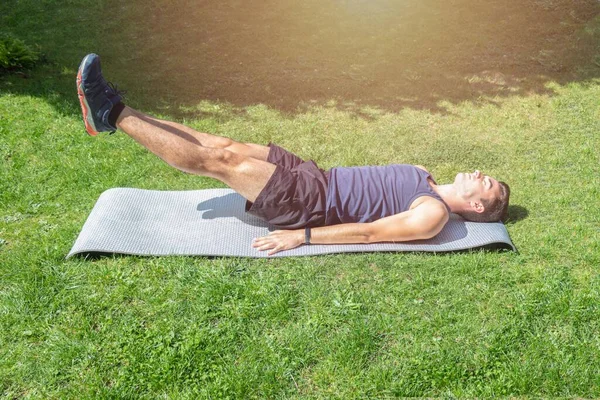 Jovem Deitado Tapete Fazendo Exercícios Musculação Reforço Abdominal Levantando Pés — Fotografia de Stock