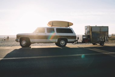 Araba sürüş ekipman ile asfalt yolda tropik adada, otomobil longboards aktif spor hobi ile tur seyahat sırasında sörfçü mal taşıma okyanus kıyı Park