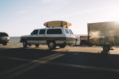Okyanus kıyısında asfalt yolda güneşli günde sürüş sörf için ekipman ile otomobil, araba ile yaz tatili aktif sportif hobi üzerinde harcama için üstte longboards se Park