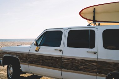 Ekipman spor hobi deniz kıyısında aktif tatiller eğitim longboard taşıma sörf moda yaz sonları, eski okyanus kıyısından otomobil kamyonla kırpılmış görüntü