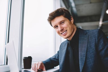 Zengin işadamı; online hizmet için ödeme ve hareket memnun banka hesabı teyit kamera bakıyor; dizüstü bilgisayarda Web sitesi tarama müreffeh erkek yönetmen portresi