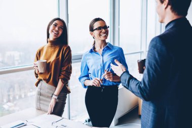 Erkek patron üretken işlemle memnun ile görüşme sırasında dostça konuşma işbirlikçi çalışma işlemi sırasında kahve molası sırasında olumlu iş arkadaşları gülümseyerek neşeli kadın çalışanların