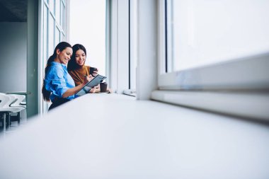 Coworking ofis, ortak proje için fikirler tamamlanan başlangıç planlama hakkında iletişim başarılı iş kadınları tartışırken arka plan neşeli erkek meslektaşları ile verimli iş memnun