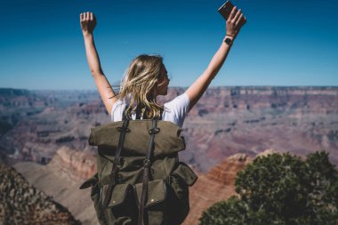 Eller yukarı, mutlu kadın traveler tur ABD'de hiking sırasında zirveye ulaşma başarı kutluyor sırt çantası ile heyecanlı hippi kız ücretsiz duygu yüksek dağın tepesinde ayakta arkadan görünüm yetiştirme