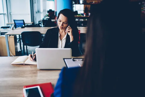 专业女经理在手机上交谈 和同事坐在一起做笔记 有经验的女商人在开会咨询员工时打电话 — 图库照片