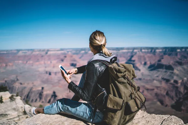 Rückansicht Einer Reisenden Die Telefon Auf Einem Hohen Berg Sitzt — Stockfoto