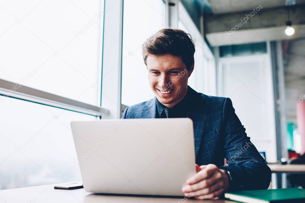 Professional executive manager satisfied with successful project checking financial news on exchange website using laptop computer,formally dressed businessman satisfied with updating software for job