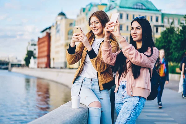 Hayran hipster turist çekim video ve çekici resimler hafta sonu gezisi zevk dijital cep telefonlarında ise new City sokakta geziniyor casual giyim giymiş. Kopyalama alanı alanı metin için