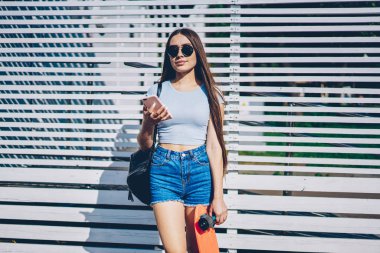 Kaykay siyah güneş gözlüğü 4 g yüksek hızlı internet bağlantısı sırasında yaz hava yolu ile smartphone multimedya dosyaları güncelleştirilirken beyaz promosyon arka plan üzerinde duran kadın sevgilisi