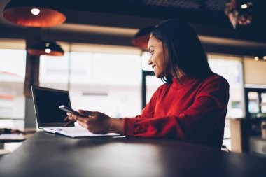 Neşeli afro Amerikan hippi kız online araştırma kafede ücretsiz Wi-Fi bağlantısı kullanarak ödev proje hazırlama yapma. Yaratıcı koyu tenli tasarımcı teknoloji planlama yapmak için kullanma