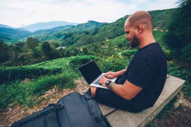 Bilgi alanı açık havada yüksek tepede bankta oturmuş internet siteniz için sahte ile modern netbook klavye yazarak dalgın sakallı erkek serbest meslek wit geen dağların güzel sahne