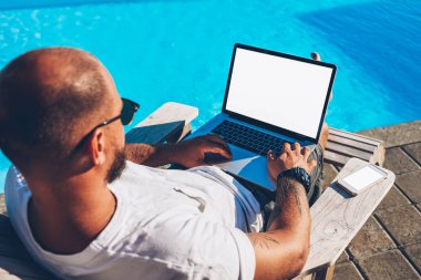 İnternet sitelerinde bilgi arama ve modern netbook boş kopya alanı ekran reklam bilgin şezlong üzerinde yalan sırasında içerik ile çalışan erkek freelancer Üstten Görünüm